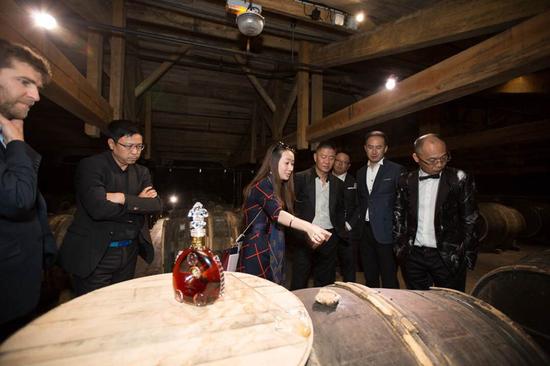 路易十三傳訊經理史佳瓊（左三）向好友們介紹用于陳釀生命之水的專屬蒂爾肯橡木桶。它由樹齡達150年的利木贊橡木制成，是成就路易十三傳奇的獨特珍寶，除路易十三之外任何干邑都無此殊榮。